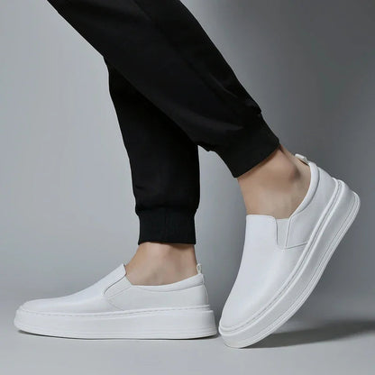 White leather slip-on sneakers for men with elastic gores and platform sole worn with black joggers