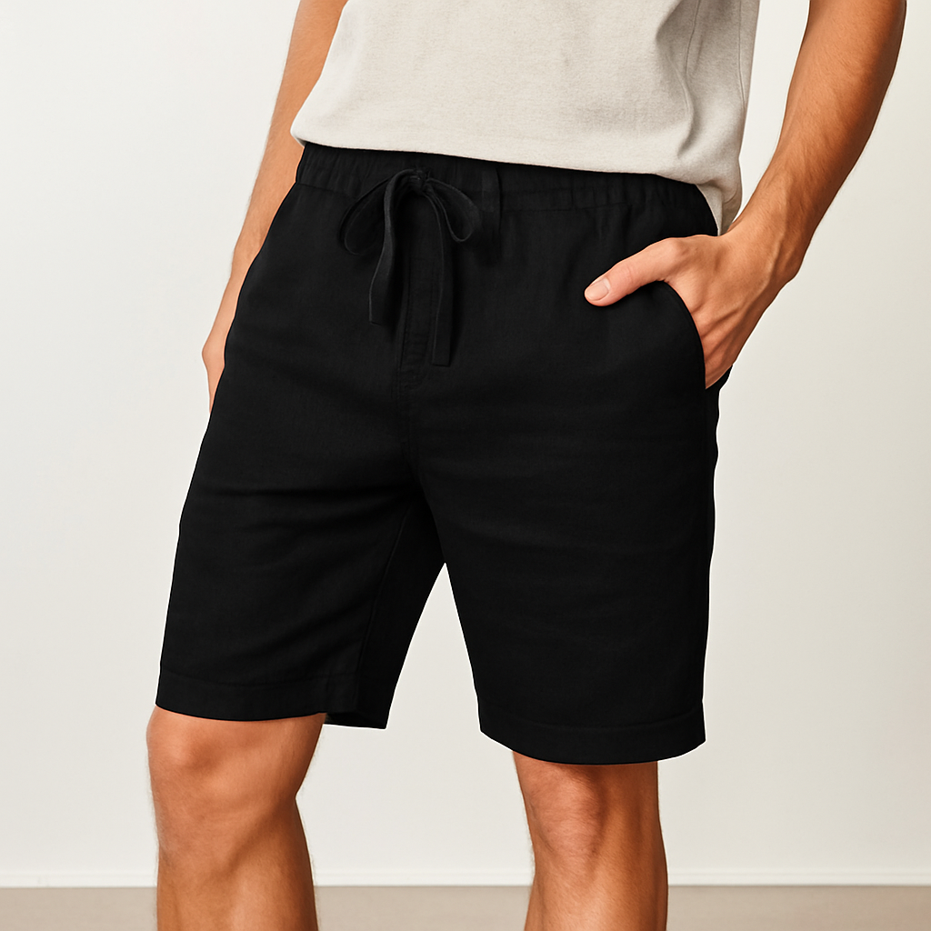 Men's black linen drawstring shorts with elastic waistband and side pockets, paired with a light gray t-shirt.