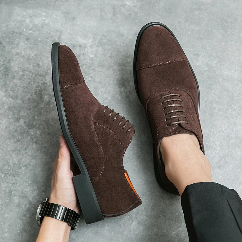 Dark brown suede cap-toe Oxford dress shoes with lace-up closure and rubber sole, shown on foot and in hand.