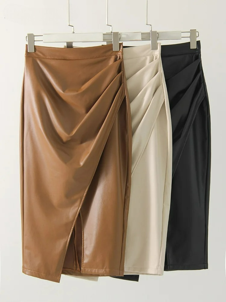 Three women's vegan leather wrap midi skirts hanging on hangers in brown, cream, and black with ruched front detail.
