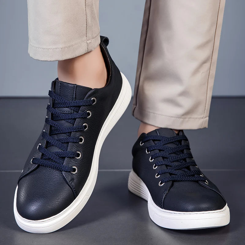 Navy blue leather lace-up sneakers for men with white sole and casual design worn with beige chinos