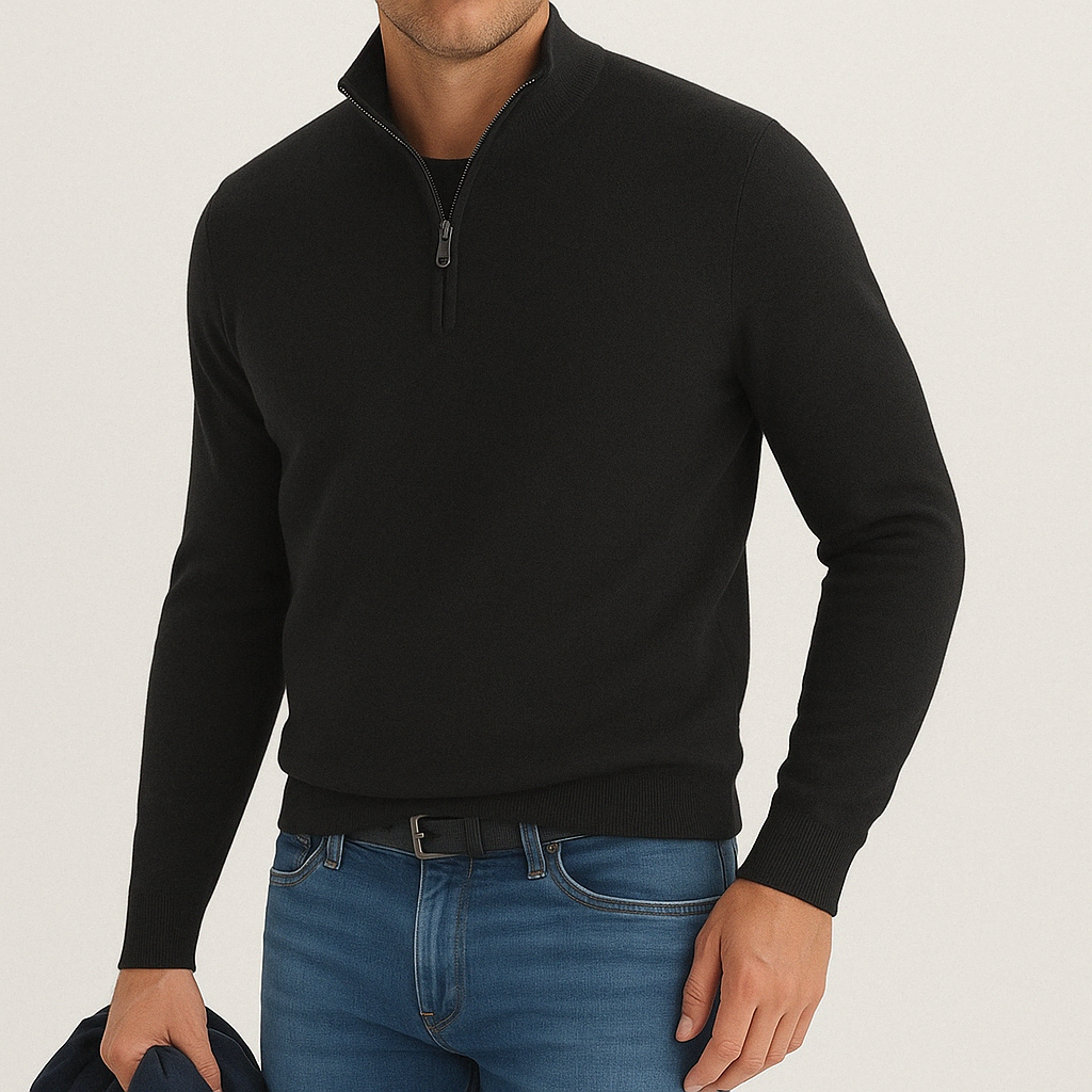 Man wearing a black cashmere blend quarter-zip sweater paired with blue jeans and a black belt.