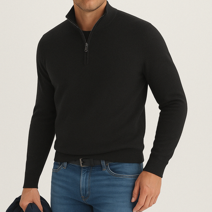 Man wearing a black cashmere blend quarter-zip sweater paired with blue jeans and a black belt.