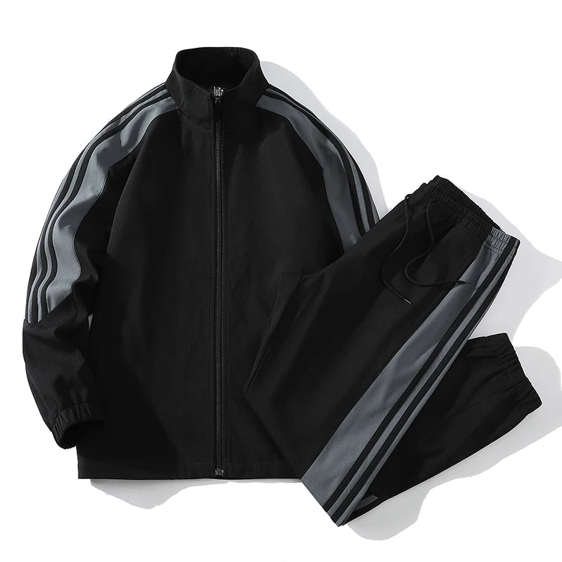 Black men's full-zip tracksuit set with gray stripe detail on sleeves and pant legs, stand collar jacket and jogger pants