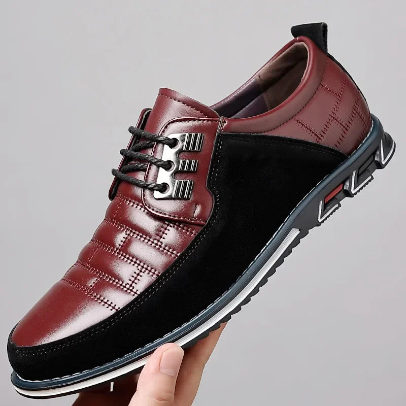 Men's burgundy and black leather lace-up derby dress shoes with quilted pattern and chunky sole, held in hand