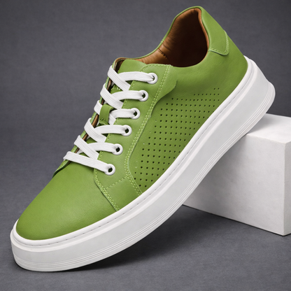Green leather men's lace-up sneakers with perforated side detail and white chunky sole, displayed on white block