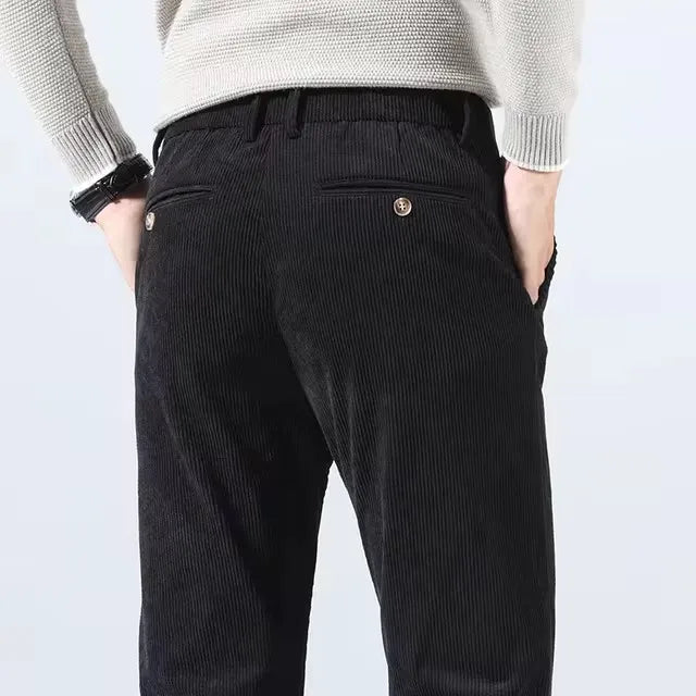 Black corduroy slim fit chino pants for men, back view showing button pocket detail and ribbed texture fabric