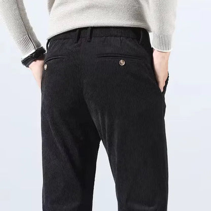 Black corduroy slim fit chino pants for men, back view showing button pocket detail and ribbed texture fabric