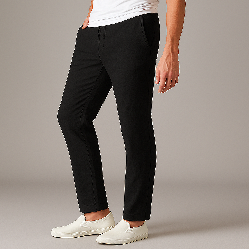 Black drawstring linen pants for men with relaxed fit, worn with white slip-on sneakers
