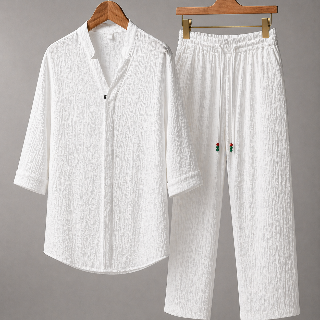 White textured cotton linen men's shirt and pants set with red rose embroidery detail on wooden hangers
