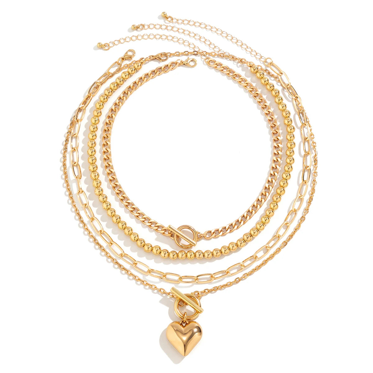 Gold layered necklace set featuring curb chain, bead strand, paperclip chain, and heart pendant with toggle clasp
