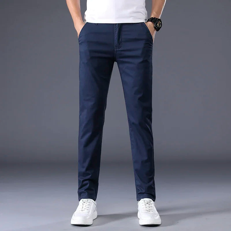 Man wearing slim fit navy blue cotton dress pants with white sneakers and white t-shirt, casual smart style