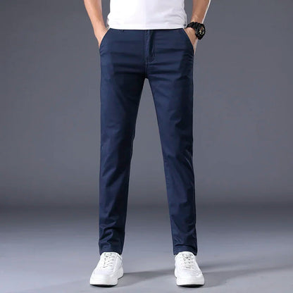 Man wearing slim fit navy blue cotton dress pants with white sneakers and white t-shirt, casual smart style