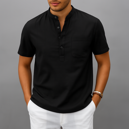 Men's black linen band collar henley shirt with short sleeves, chest pocket, and three buttons, paired with white pants.