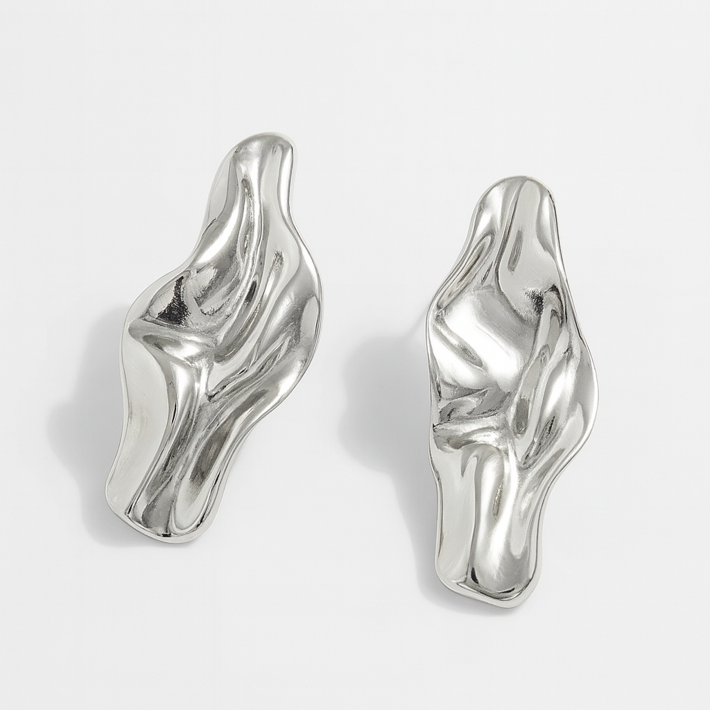 Chunky silver abstract twisted drop earrings with fluid sculptural design and high-polish metallic finish, sold as a pair.