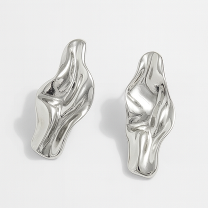Chunky silver abstract twisted drop earrings with fluid sculptural design and high-polish metallic finish, sold as a pair.