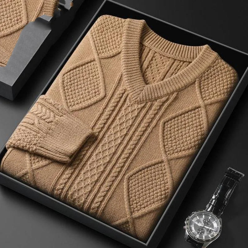 Camel cable knit v-neck wool sweater folded in gift box, displayed with a black leather watch on dark background.