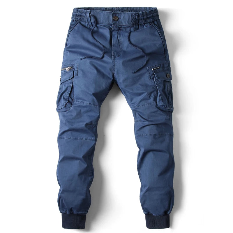 Men's blue slim-fit cotton cargo joggers with elastic waistband, drawstring, side zip pockets, and ribbed cuffs.