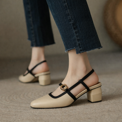 Women's beige Italian leather block heel slingback sandals with black straps and gold buckle detail, paired with jeans