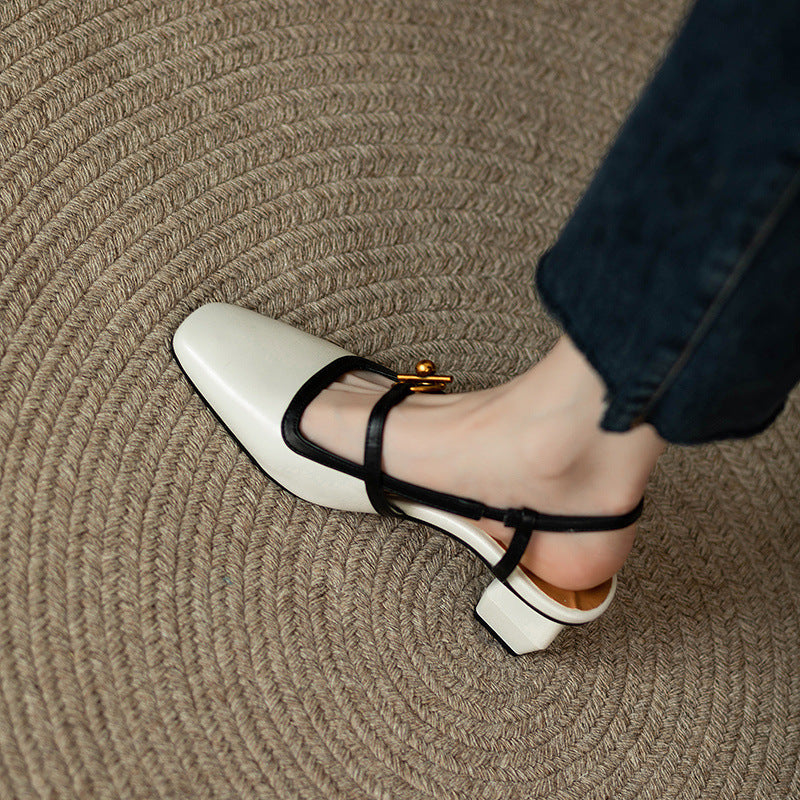 Women's cream Italian leather block heel sandals with black straps and gold buckle detail, paired with blue jeans