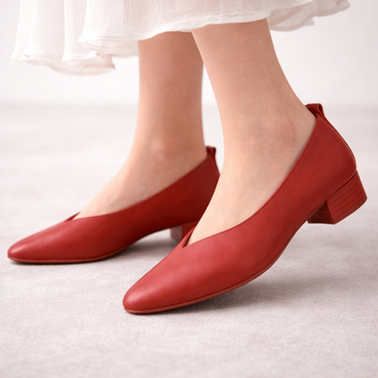 Red leather block heel pumps with V-cut vamp and square toe, shown on feet with white dress, low stacked heel