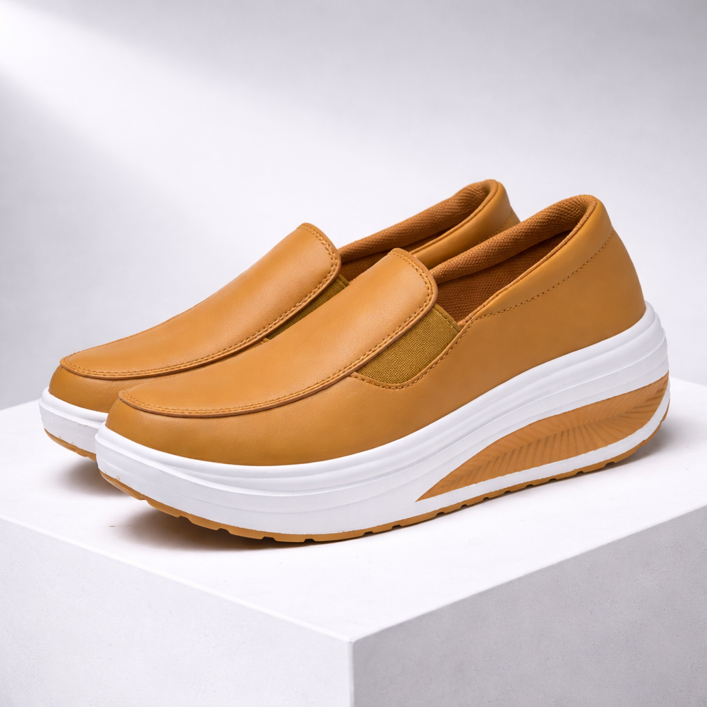 Women's tan leather slip-on platform sneakers with white curved rocker sole and elastic side panels