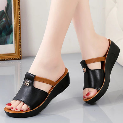 Black and tan platform slide sandals with cutout detail and wedge heel for women, red pedicure shown