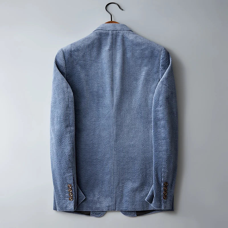 Light blue corduroy blazer jacket hanging on hanger showing back view with ribbed texture and button sleeve details