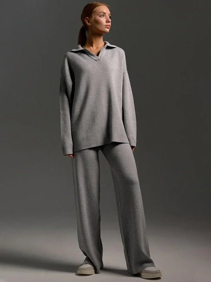 Woman wearing gray collared knit oversized sweatshirt and matching wide-leg pants loungewear set with gray sneakers.