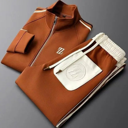 Men's rust orange zip-up track jacket and jogger pants set with white leather trim and embroidered logo detailing.