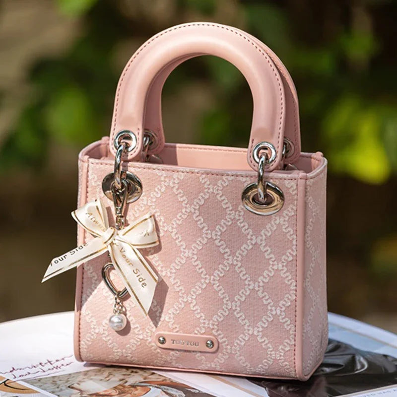 Pink jacquard mini handbag with pearl bow charm, silver hardware and top handles for women