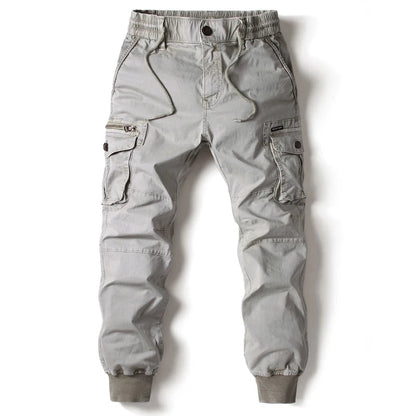 Light gray men's slim-fit cargo jogger pants with elastic waistband, drawstring, side zip and flap pockets, ribbed cuffs.