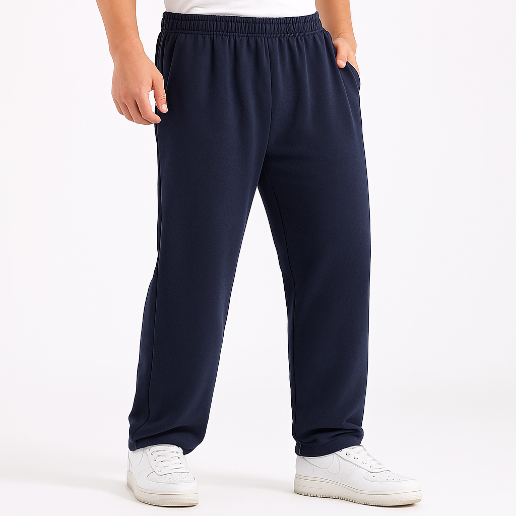 Navy blue men's cotton sweatpants with elastic waist and side pockets, paired with white sneakers, relaxed fit.