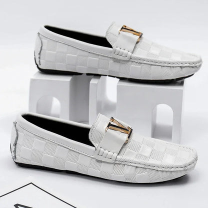 White checkered slip-on loafers for men with gold metal V-buckle detail and moccasin stitching, displayed on white blocks