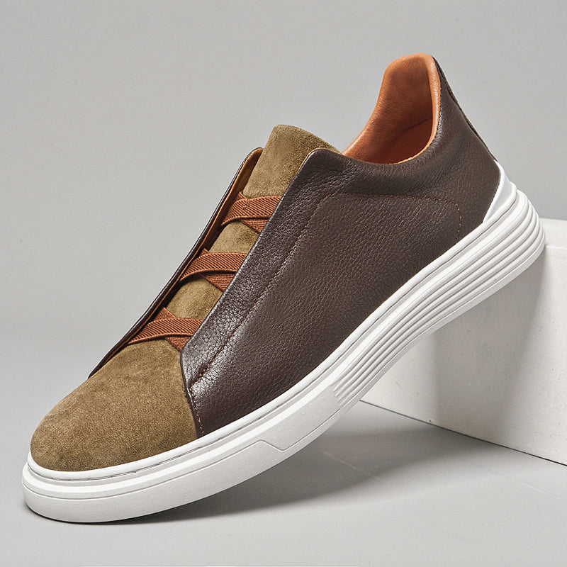 Mens orthopedic sneakers with brown leather and tan suede upper, elastic laces, and white sole on gray background