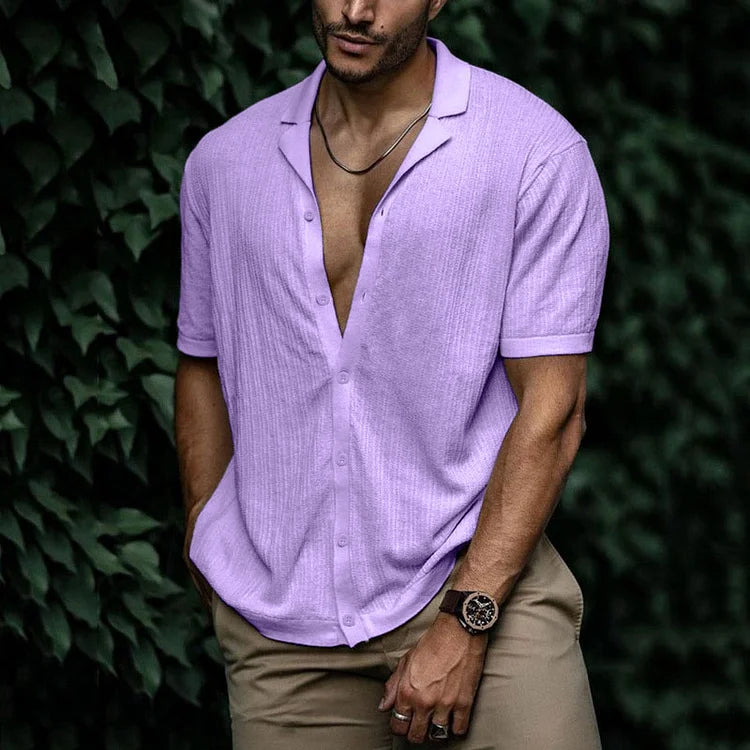 Man wearing lavender short sleeve button-down knit shirt with open collar, paired with khaki pants and watch.