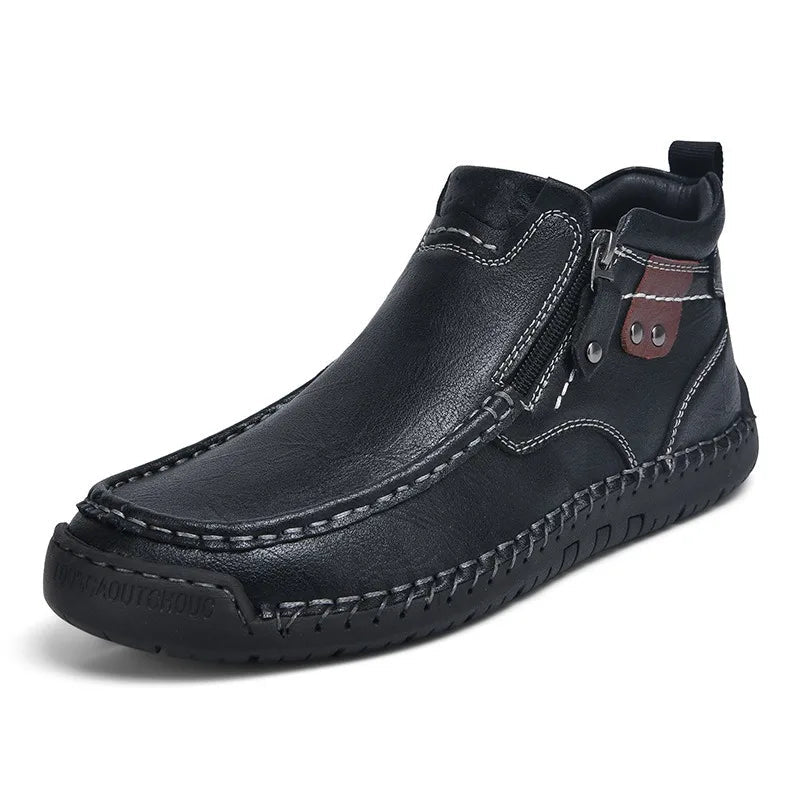 Black men's leather ankle boots with side zipper, contrast stitching, brown accent patch, and rubber outsole