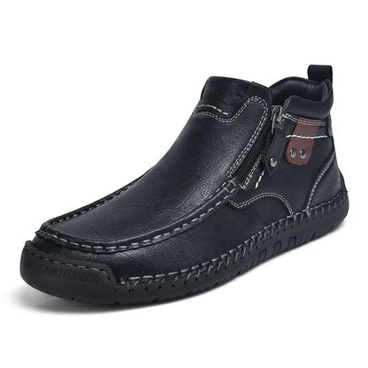 Black men's leather ankle boots with side zipper, contrast stitching, brown accent patch, and rubber outsole