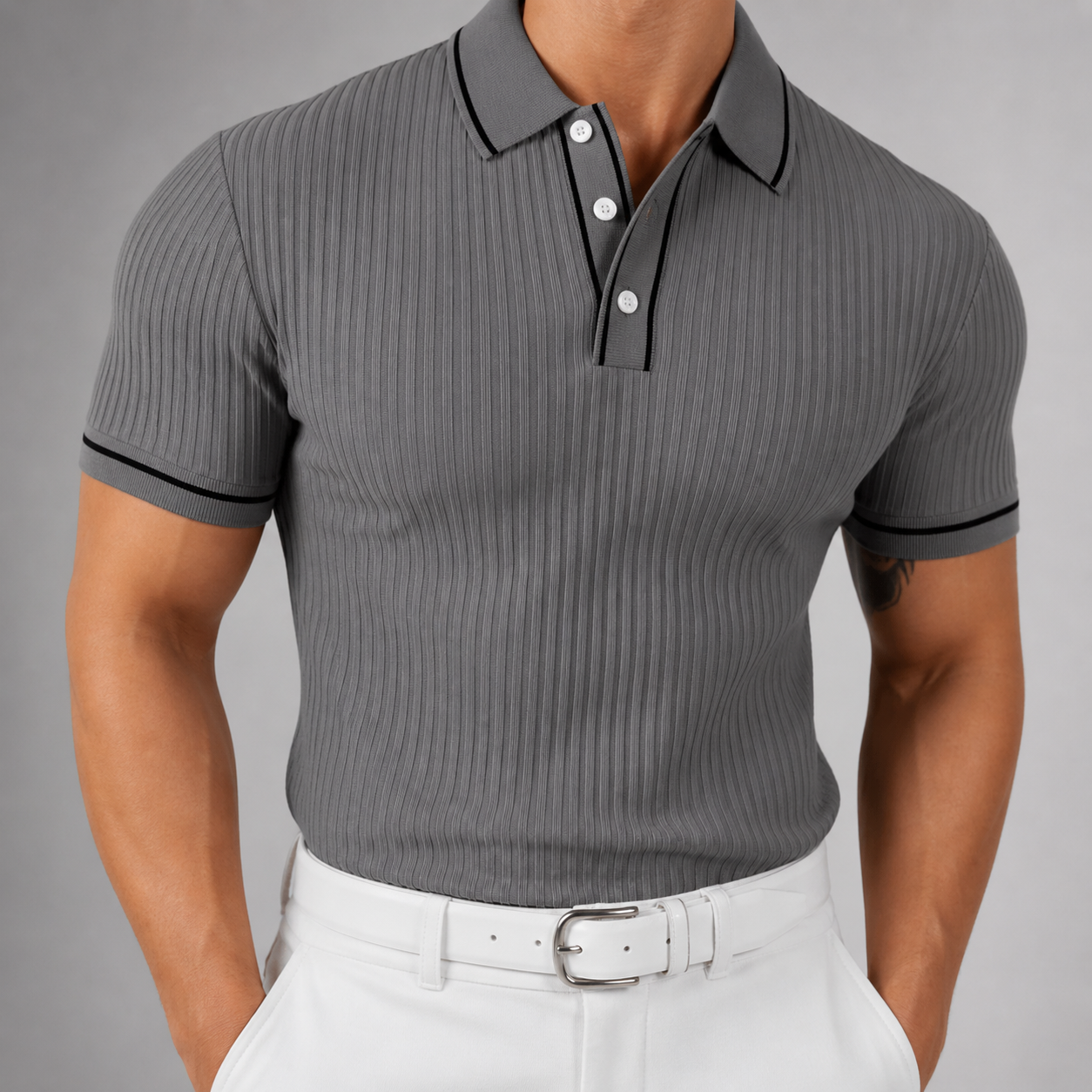 Men's slim-fit gray ribbed knit polo shirt with black contrast trim, white buttons, and short sleeves, paired with white trousers.