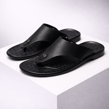 Black men's leather thong flip-flop sandals with textured footbed and small metal logo detail, displayed on white block.