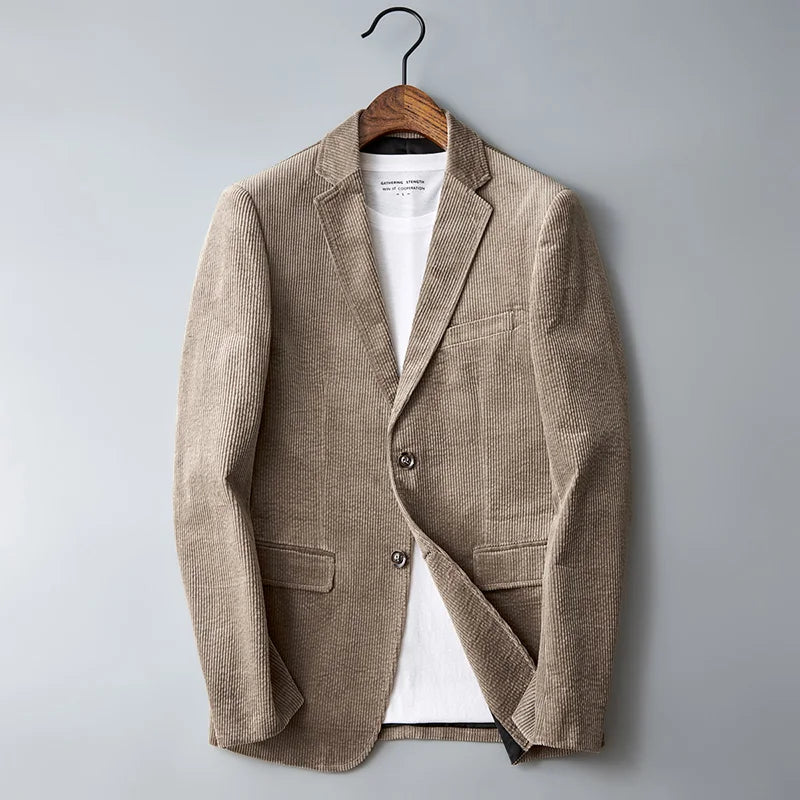 Beige corduroy men's blazer jacket with notch lapels, two buttons, and chest pocket, styled over white tee on wooden hanger