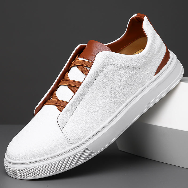 White leather men's slip-on sneakers with brown contrast trim, elastic laces, and thick white rubber sole.