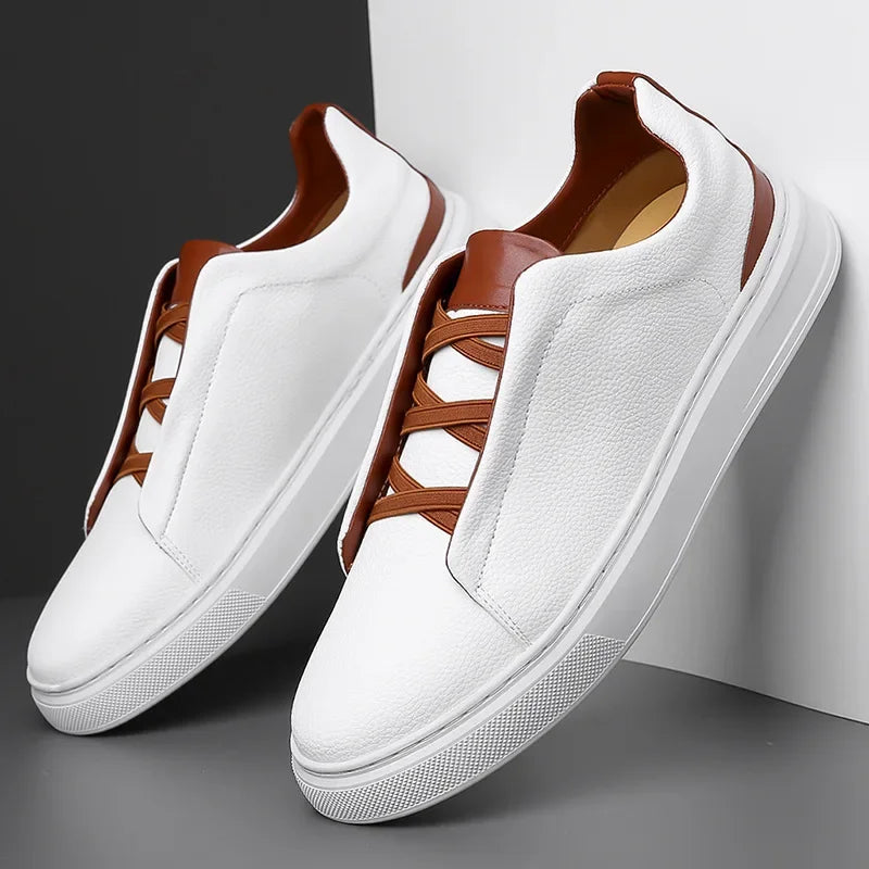 White leather men's slip-on sneakers with brown elastic laces, contrast trim collar, and flat white rubber sole.