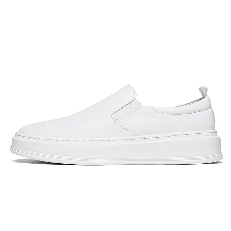 White leather slip-on loafer sneakers for men with elastic side panels and thick white platform sole, side view.